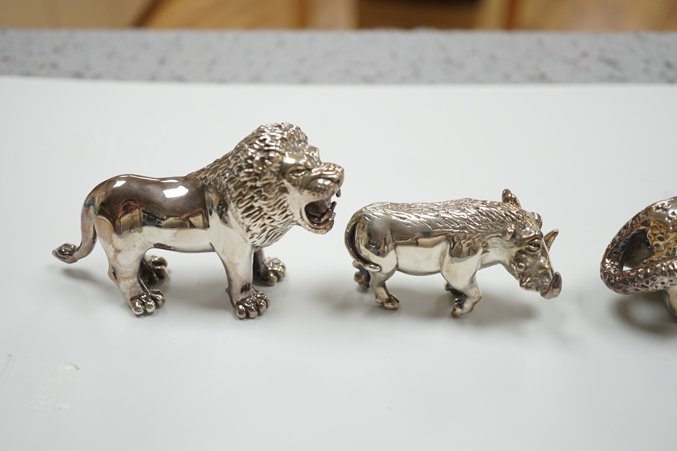 Four modern 925 overlaid miniature models of animals including two lions and a similar leopard napkin ring (one lion a.f.).